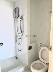 Modern white bathroom with wall-mounted toilet and shower