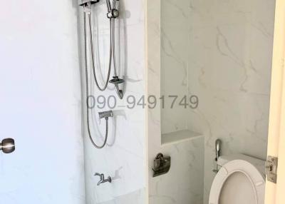 Modern white bathroom with wall-mounted toilet and shower