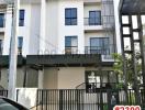 Modern two-story residential building with balcony and gated entrance