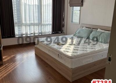 Spacious bedroom with queen-size bed and large windows