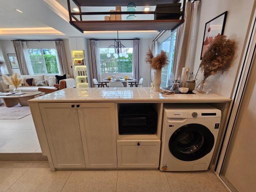 Modern kitchen with open plan layout featuring integrated appliances and a view towards the dining area