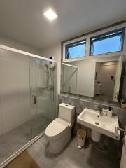 Modern bathroom with glass shower enclosure and skylight windows