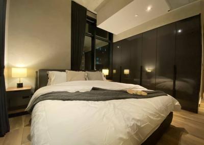 Modern bedroom interior with king-size bed and city view at night