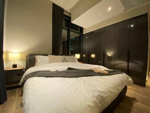 Modern bedroom interior with king-size bed and city view at night