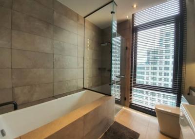 Modern bathroom with glass shower enclosure and city view