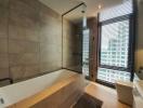 Modern bathroom with glass shower enclosure and city view