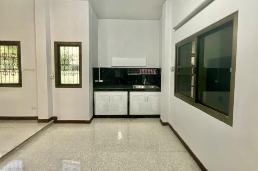 Spacious kitchen with modern cabinetry and glossy tiled flooring