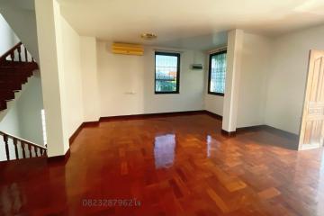 Spacious living room with glossy wooden flooring and staircase