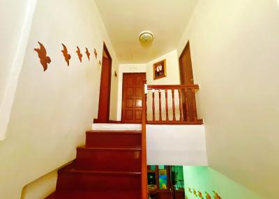 Cozy staircase with wooden railing and decorative wall art