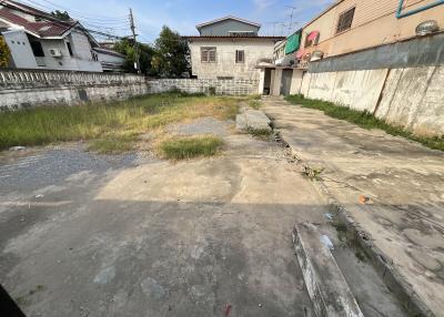 Spacious vacant lot with concrete foundation and surrounding residential buildings