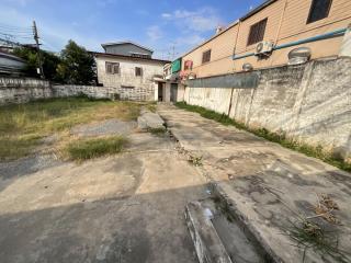 Empty lot adjacent to residential buildings with a concrete surface