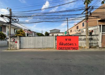 Street view of a property for sale with a visible for-sale sign and surrounding neighborhood