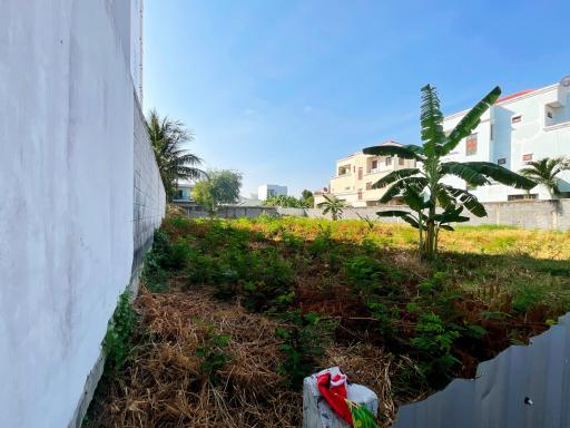 Spacious undeveloped outdoor area with greenery near buildings