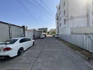 Quiet residential street with parked cars and surrounding walls