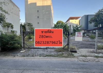 Vacant land plot for sale with a for-sale sign in Thai language