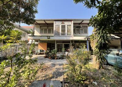 Two-story residential building with balcony and garden