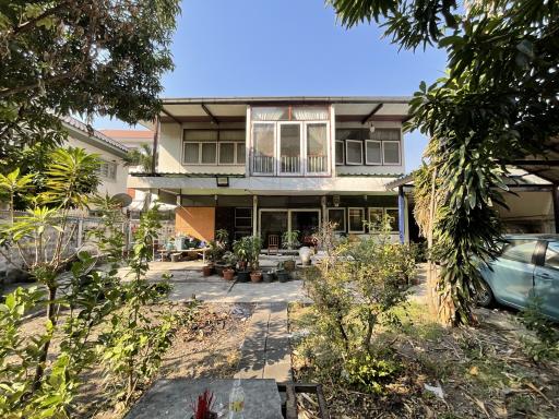 Two-story residential building with balcony and garden