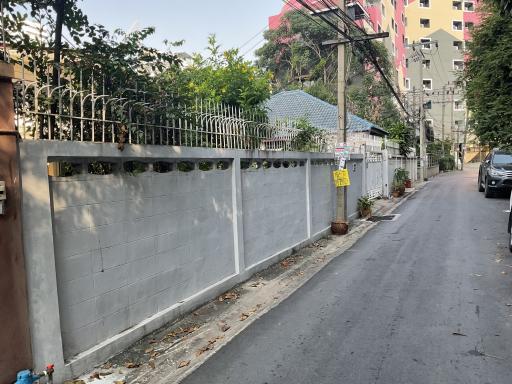 Street view of property entrance with metal gate and fence