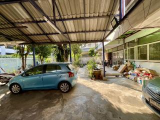 Spacious outdoor parking area with a car and storage items