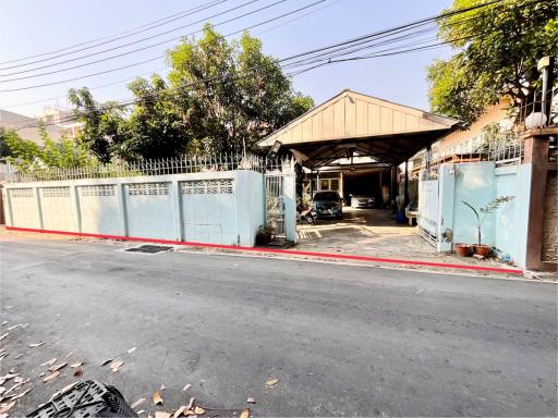 Spacious gated property exterior with covered parking area