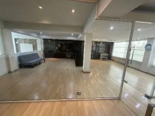 Spacious living room with large mirrors and open-plan kitchen in the background