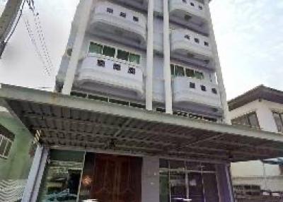 Multi-story residential building exterior with parked cars