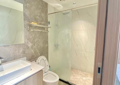 Modern bathroom interior with marble tiles and glass shower enclosure