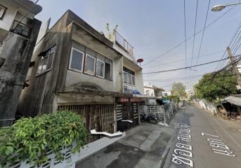 Exterior view of a two-storey residential building with a ground floor shop