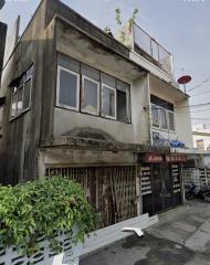 Exterior view of a two-story residential building with retail space on the ground floor