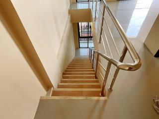 Bright and clean interior staircase with wooden steps and metal railing