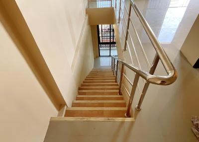 Bright and clean interior staircase with wooden steps and metal railing