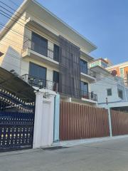 Modern multi-story residential building with balconies and gated entrance