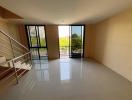 Spacious and well-lit living room with balcony access and tiled flooring