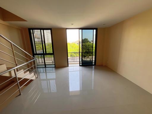 Spacious and well-lit living room with balcony access and tiled flooring