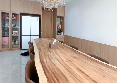 Spacious dining room with large wooden table and elegant chandelier