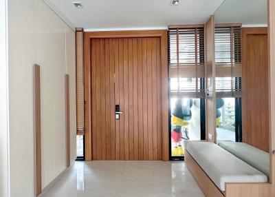 Modern entryway with wooden paneling and sleek furniture