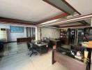 Spacious office area with multiple workstations and natural lighting