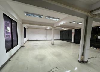 Spacious empty commercial space with large windows and tiled flooring