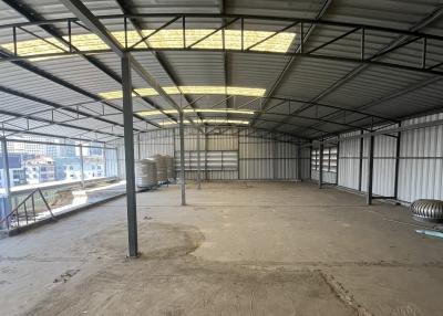 Spacious industrial warehouse interior with metal structure and skylights