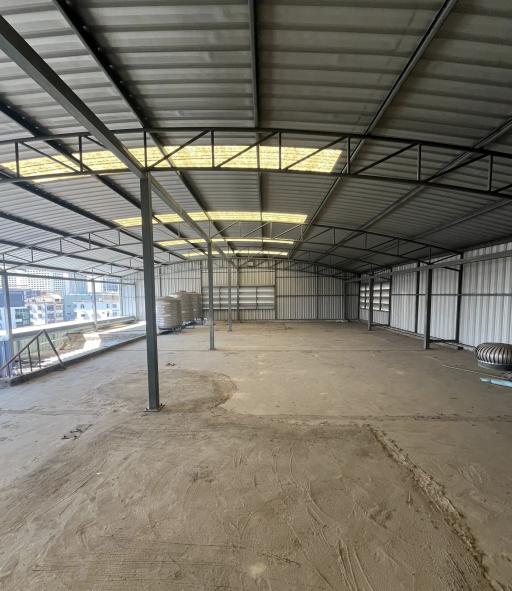 Spacious industrial warehouse interior with metal structure and skylights