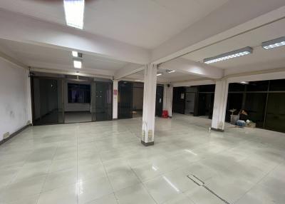 Spacious empty commercial space with tiled flooring and large windows