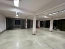 Spacious empty commercial space with tiled flooring and large windows