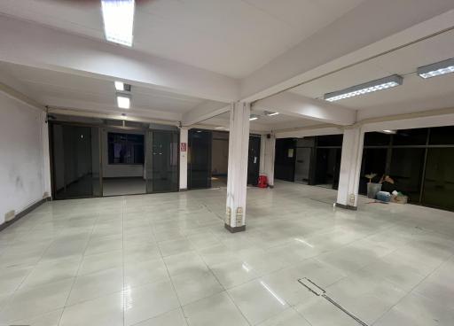 Spacious empty commercial space with tiled flooring and large windows