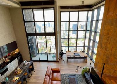 Spacious living room with high ceiling and large windows