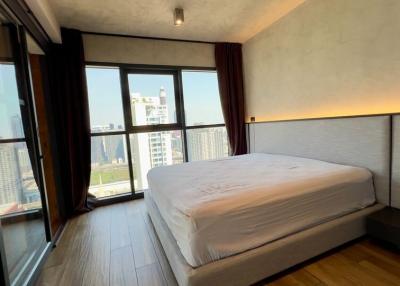 Spacious bedroom with large windows and city view