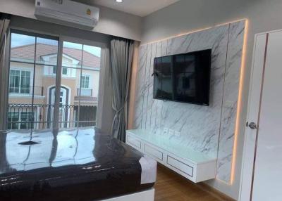 Modern bedroom with marble wall design and mounted television