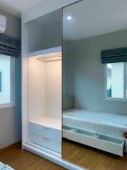 Compact modern bedroom with in-built wardrobe and large mirror