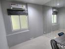 Modern bedroom with gray tiled walls, air conditioning, and large window