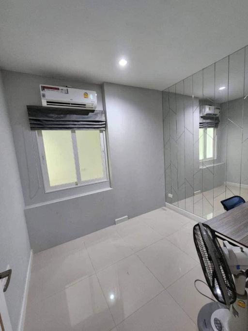 Modern bedroom with gray tiled walls, air conditioning, and large window