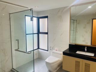 Modern bathroom with glass shower enclosure and marble walls